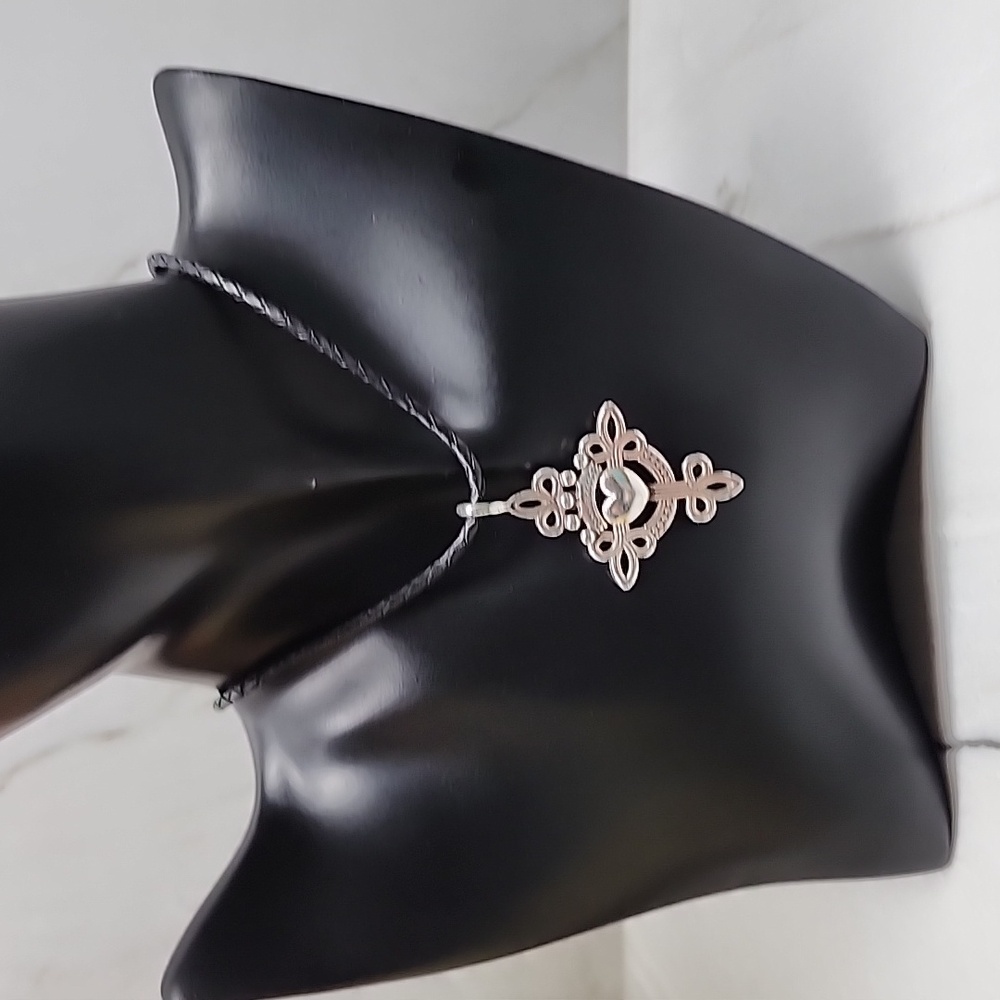 Brighton cross necklace on leather cord. Plated silver